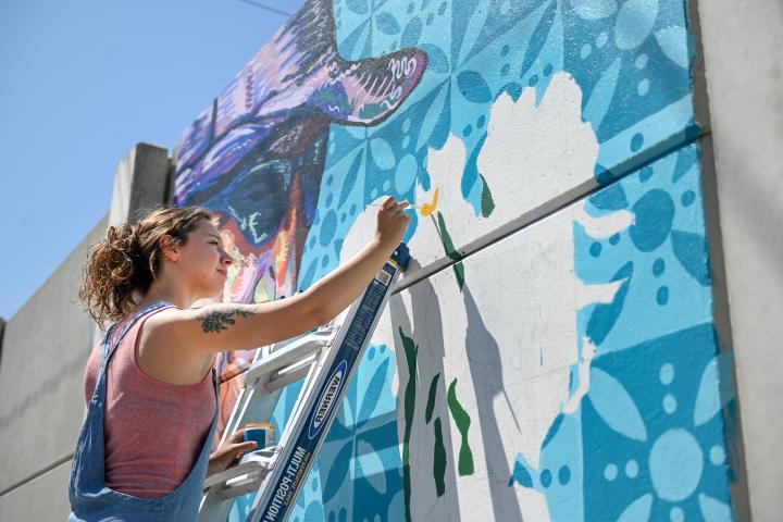 Female student painting a mural 